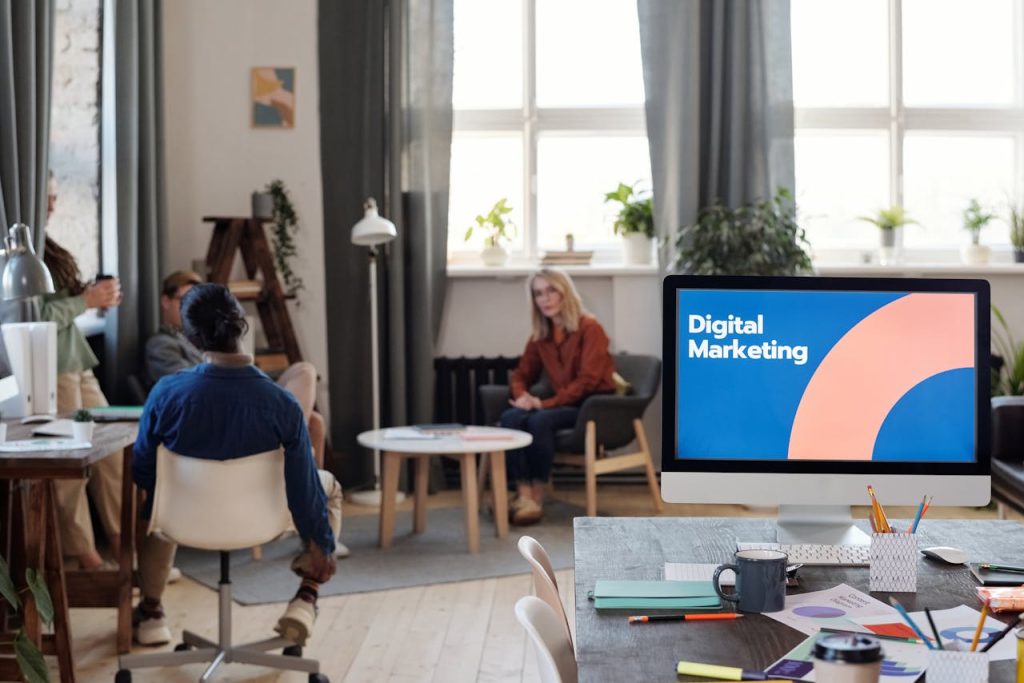 A diverse team engages in a digital marketing meeting in a stylish office setting.