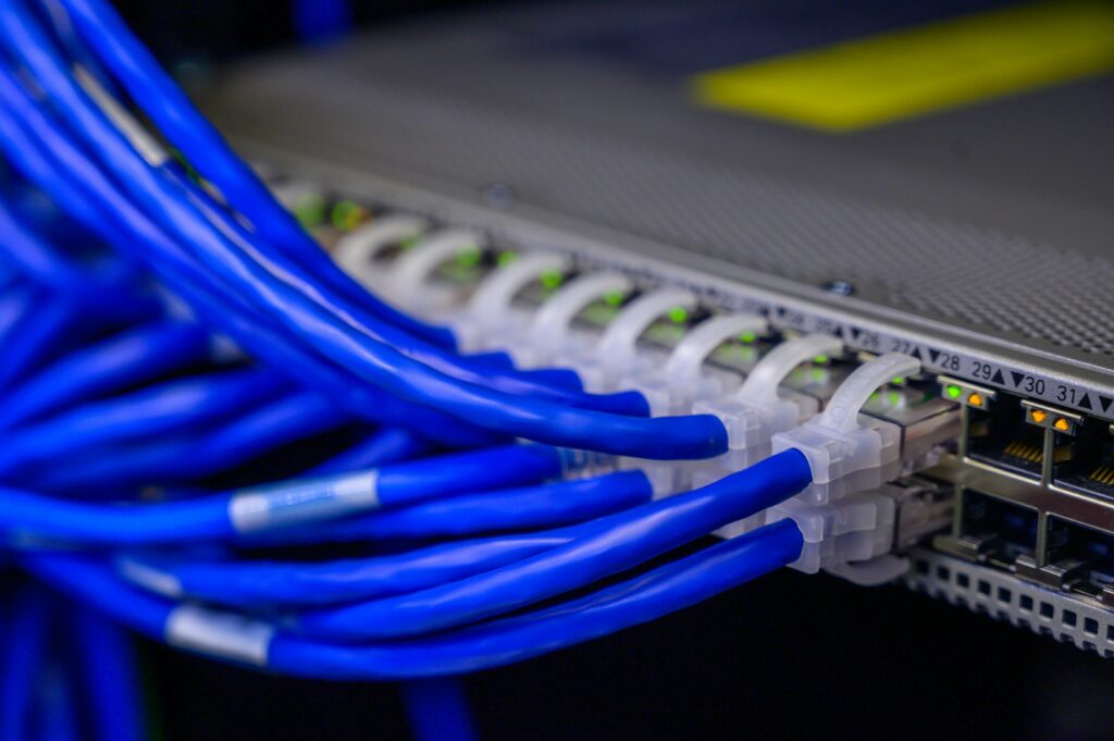 Detailed view of blue Ethernet cables connected to a network switch in a data center.